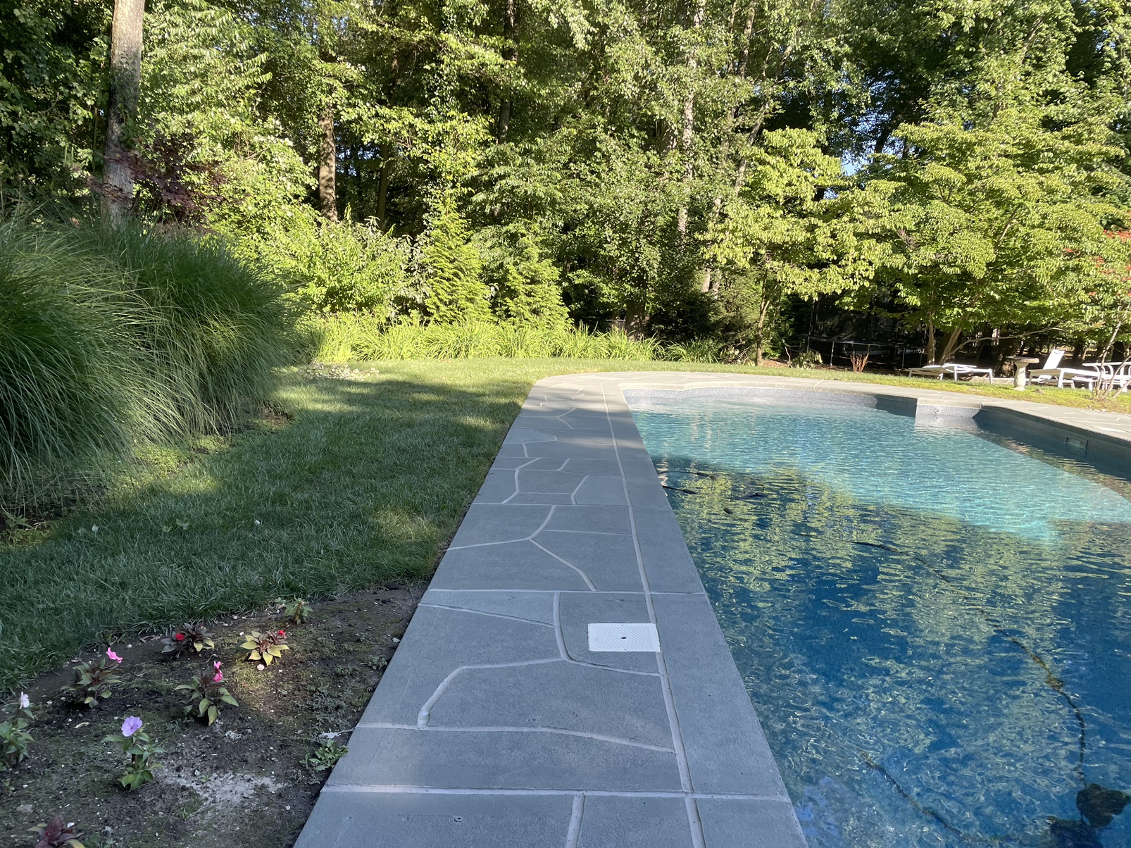 RenuKrete resurfaced pool deck in Granite Boulder showing textured stone surface