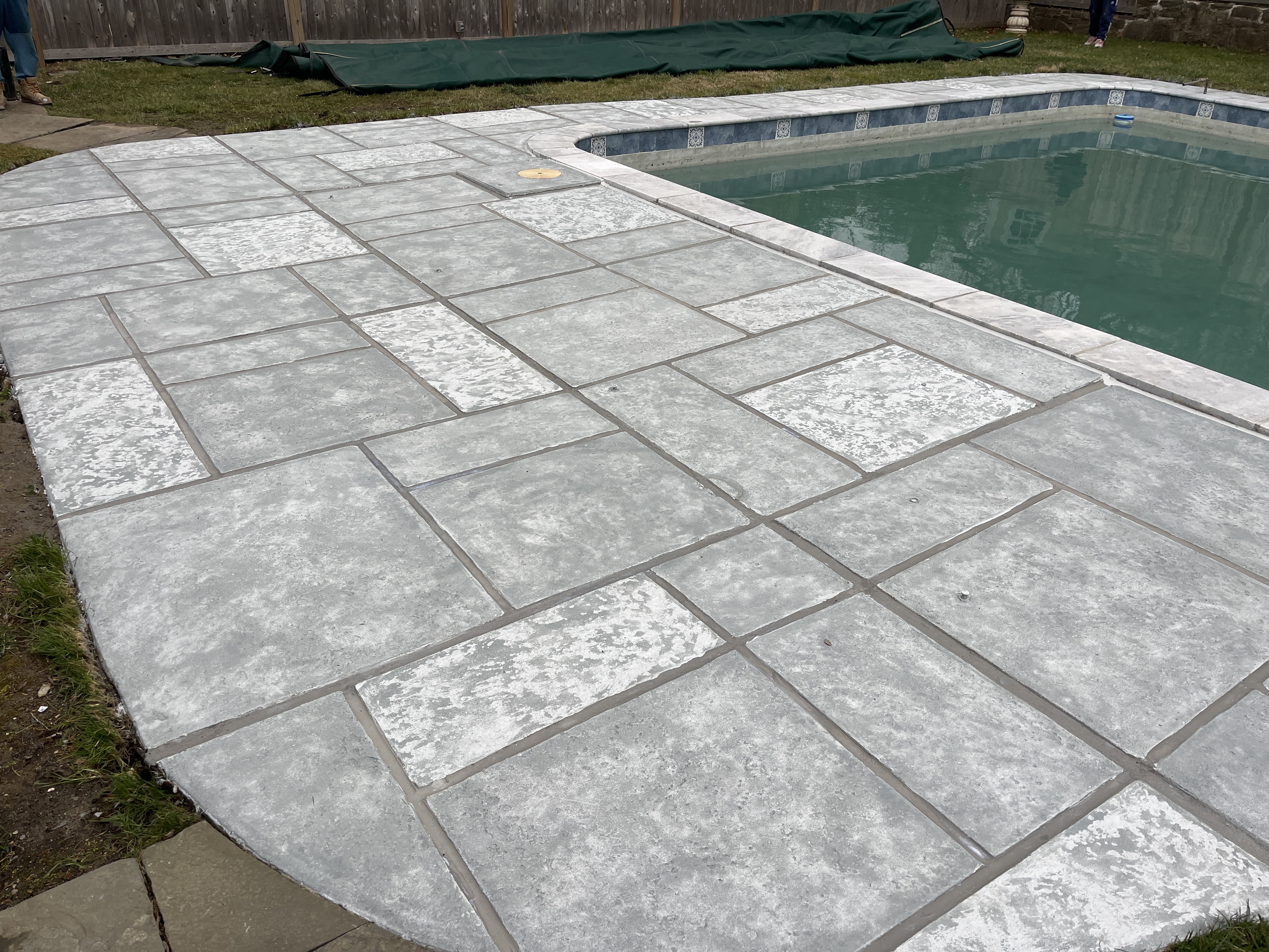Residential pool deck finished in Granite Boulder tile pattern decorative concrete