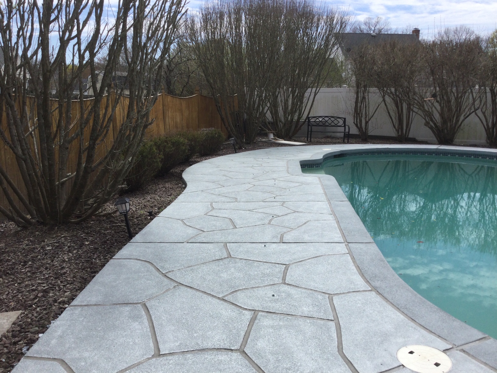 Pool deck resurfaced in Granite Boulder finish with textured stone surface