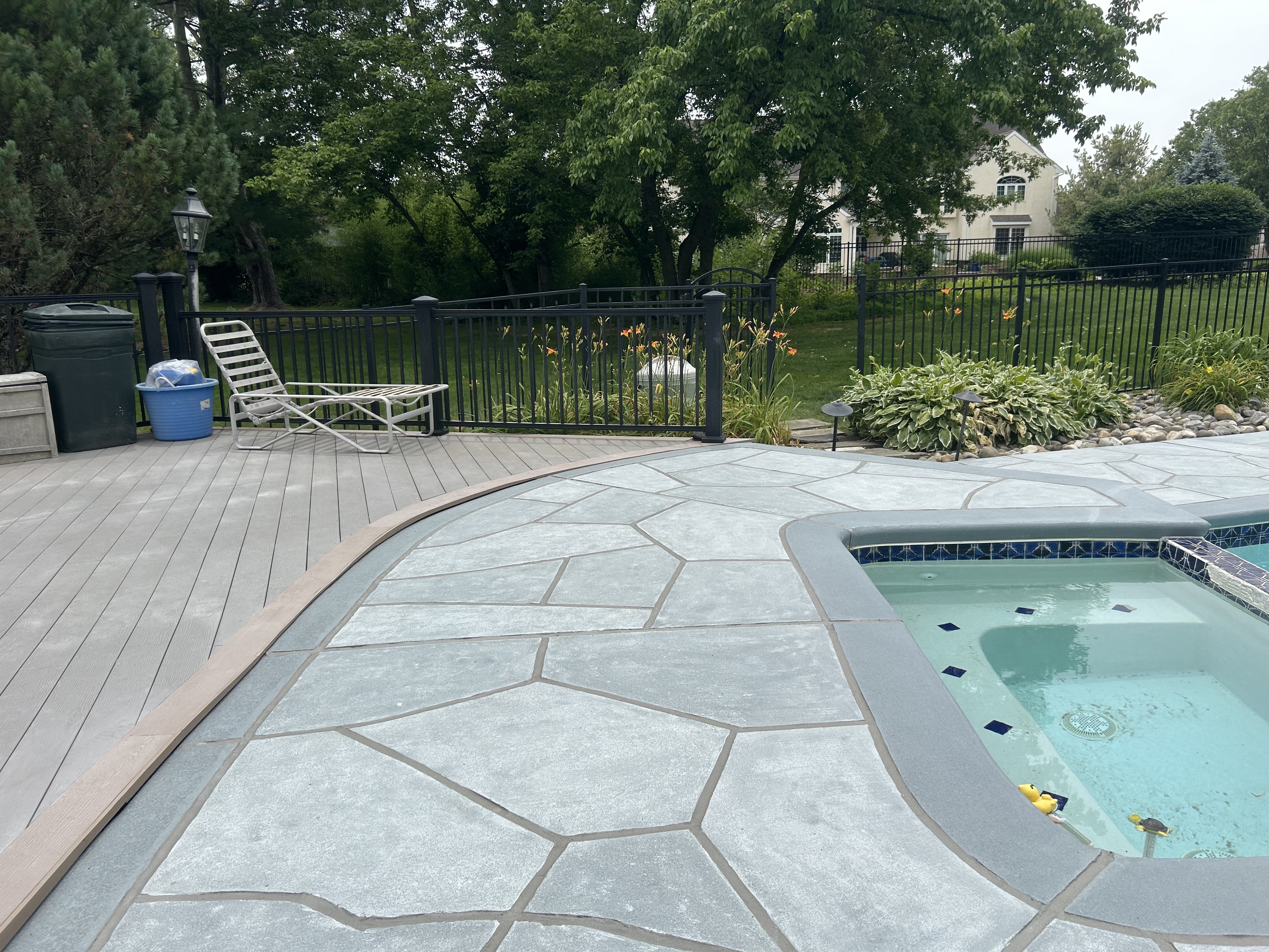 RenuKrete resurfaced pool deck in Granite Boulder showing rugged stone-like texture in Summit, NJ