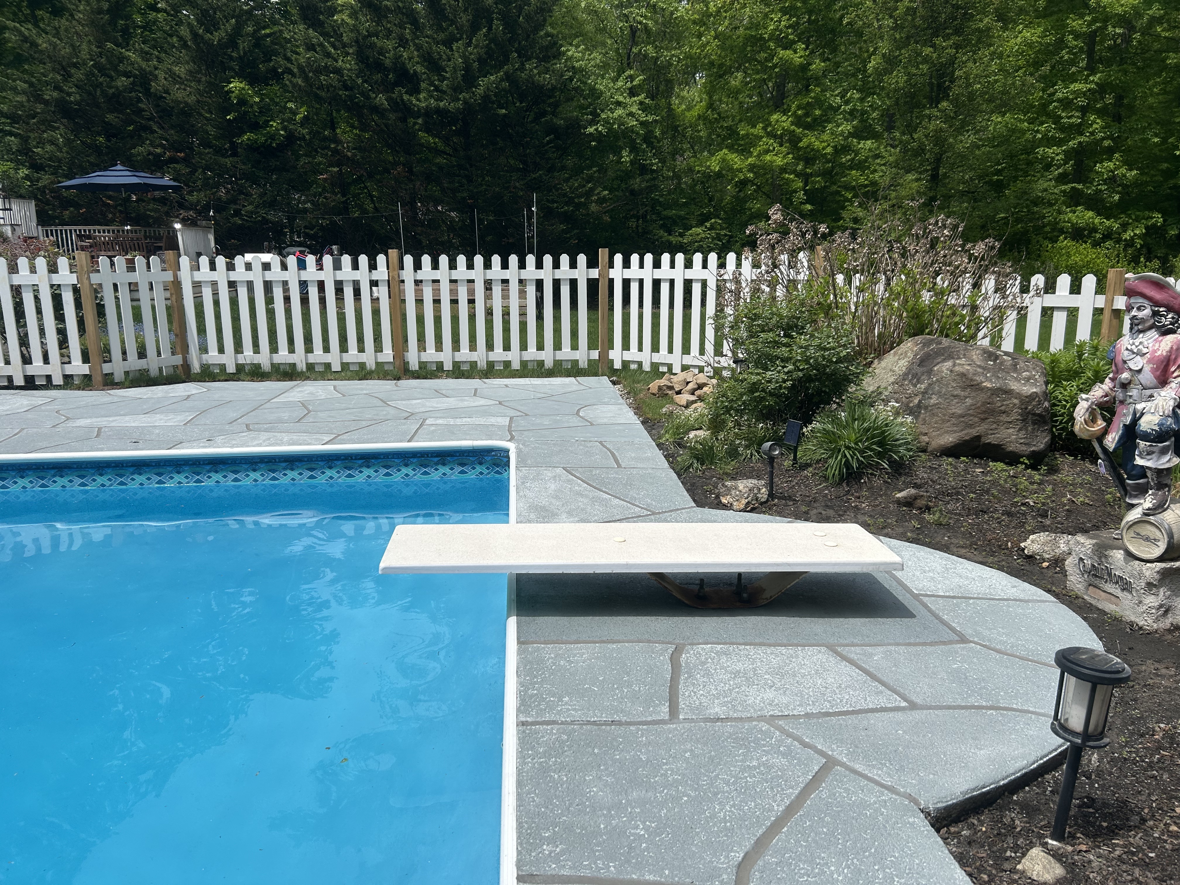 RenuKrete resurfaced pool deck in Granite Boulder showing rugged stone-like texture in Summit, NJ
