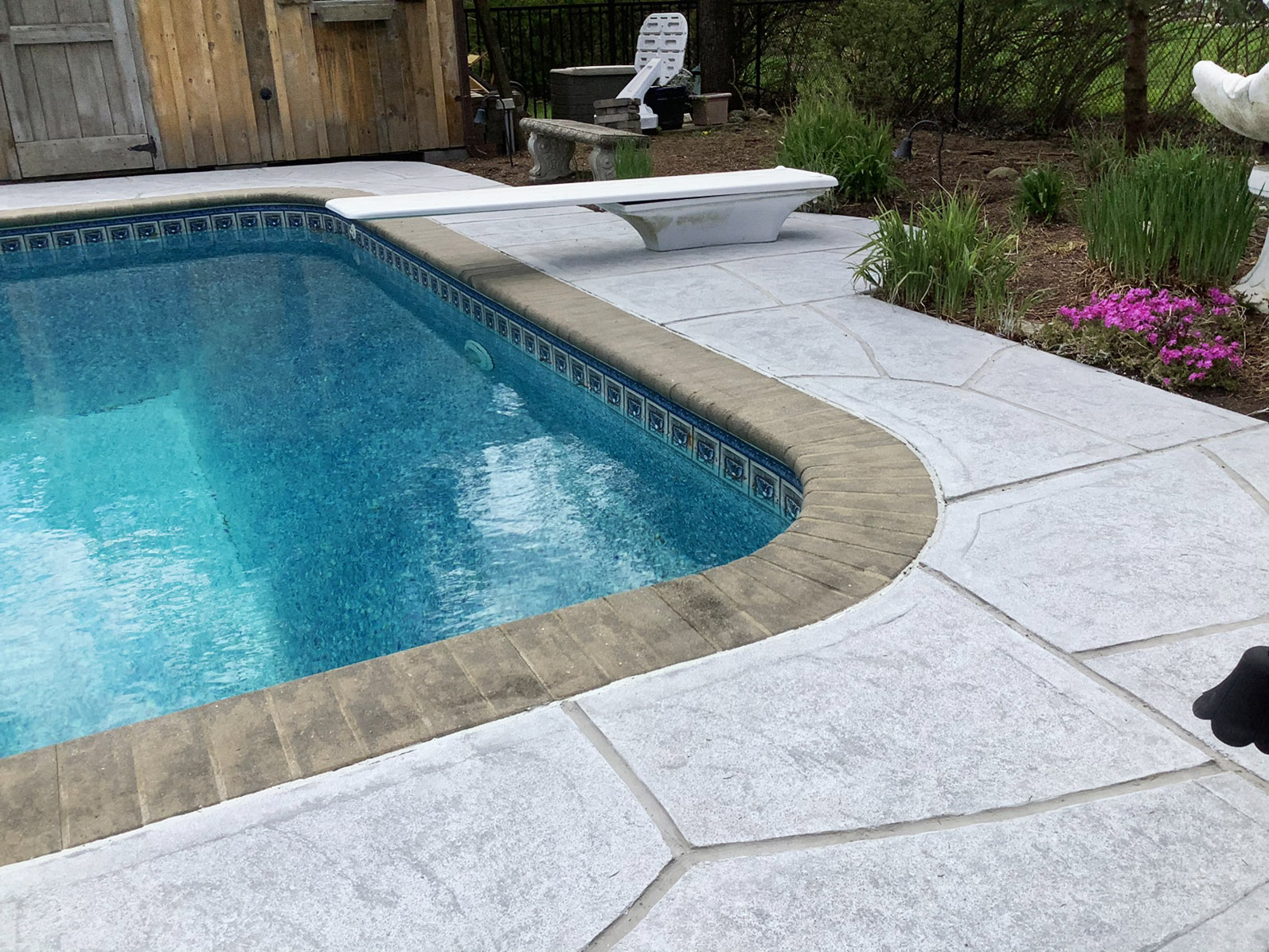 RenuKrete resurfaced pool deck in Granite Boulder showing deep gray granite tones in Princeton, NJ