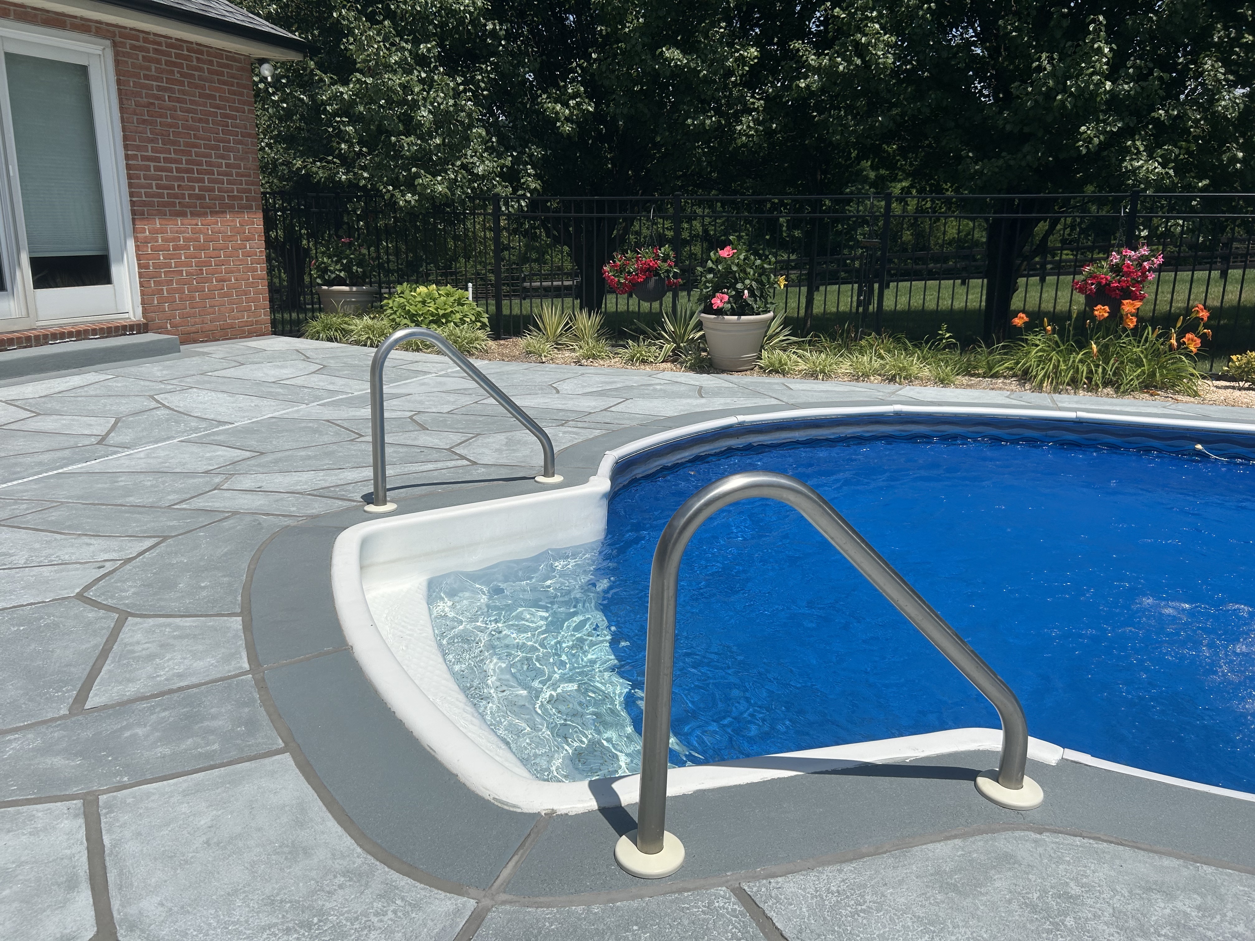 RenuKrete resurfaced pool deck in Granite Boulder showing natural boulder-inspired appearance