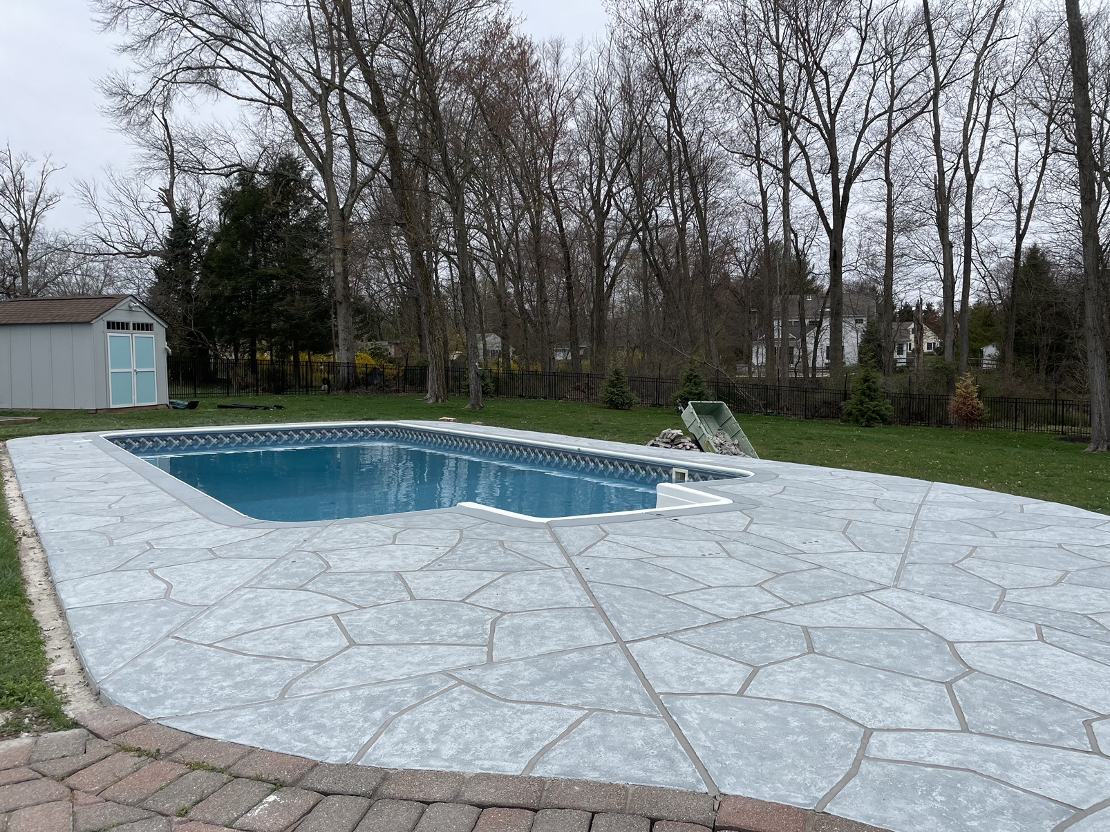 Pool deck resurfaced in Granite Boulder finish with deep gray granite tones in Marlton, NJ