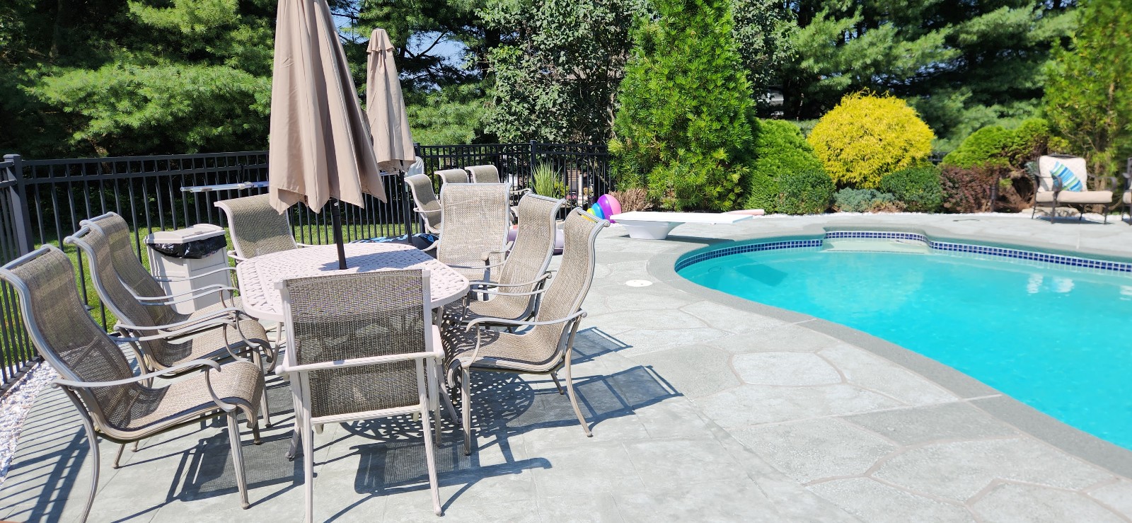Pool deck resurfaced in Granite Boulder finish with deep gray granite tones