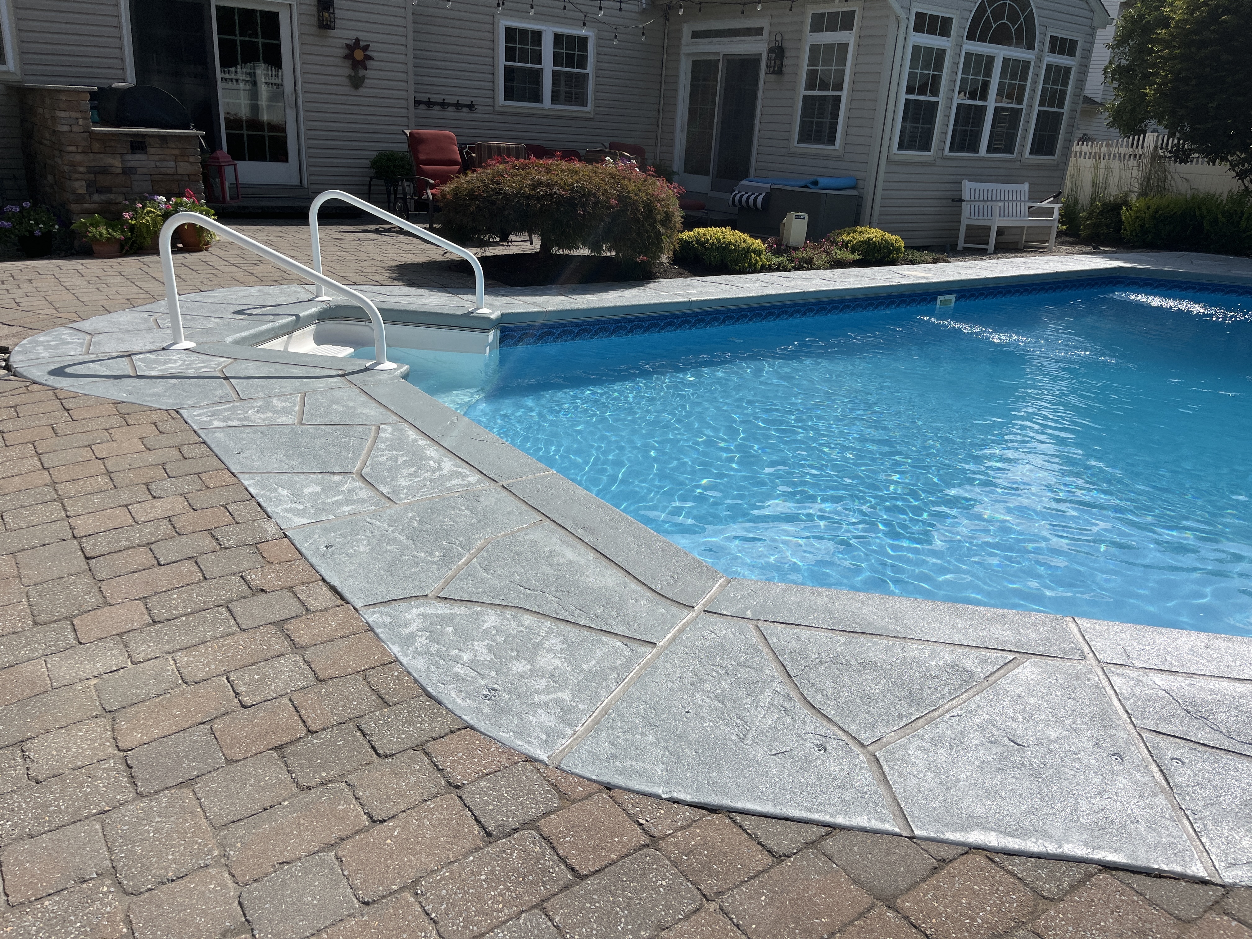 RenuKrete resurfaced pool deck in Granite Boulder showing deep gray granite tones