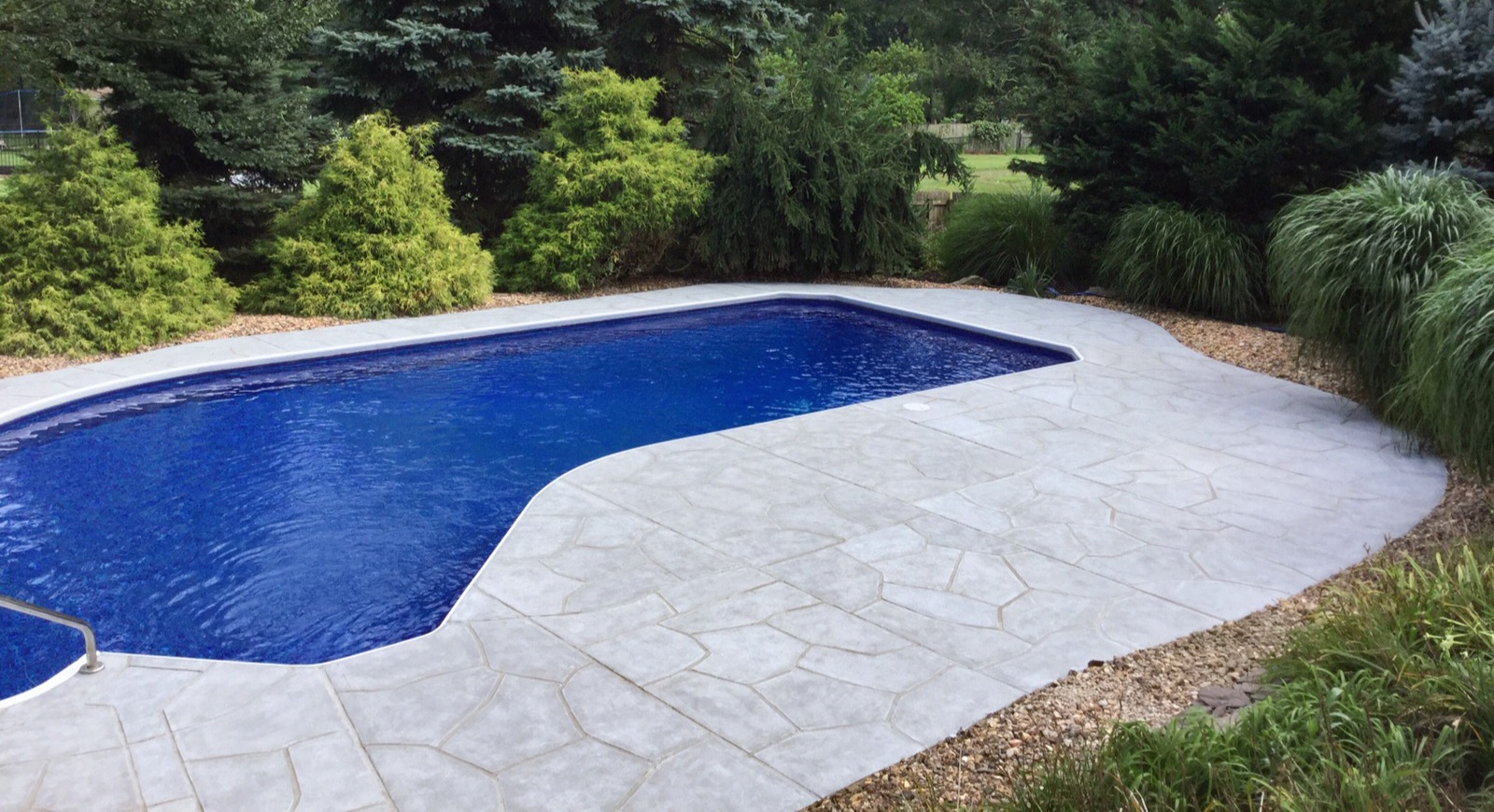 RenuKrete resurfaced pool deck in Granite Boulder showing deep gray granite tones in Providence, RI