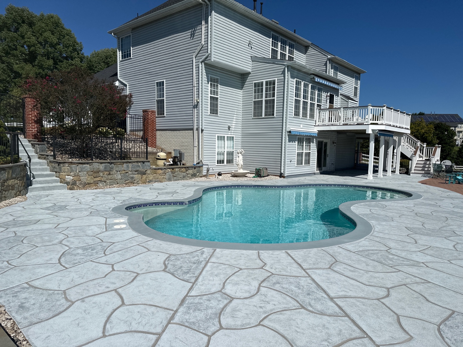 Concrete pool deck resurfaced in Granite Boulder color theme with bold stone appearance