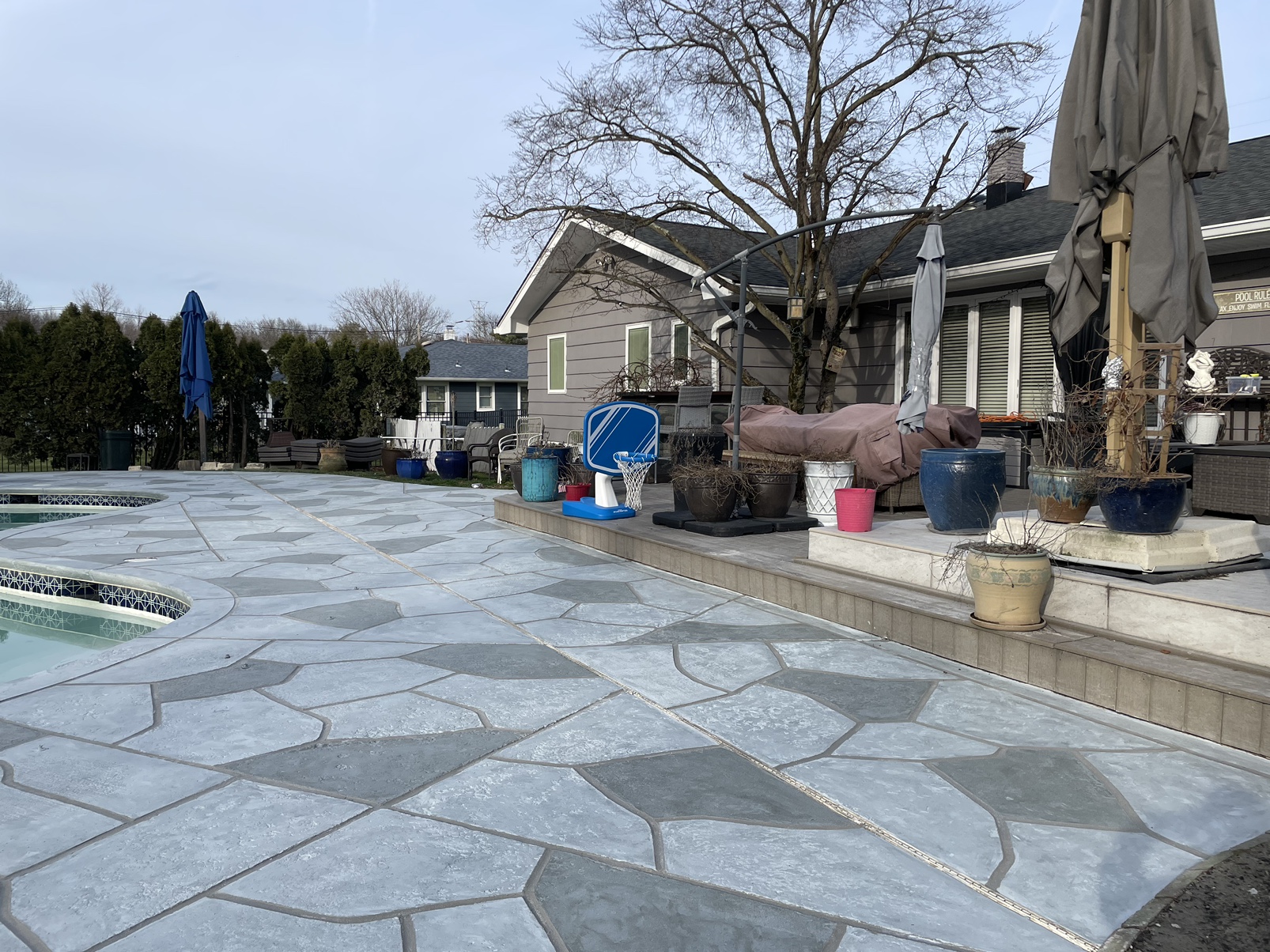 Upgraded concrete pool deck in Granite Boulder finish in Doylestown, PA with clean gray slate look.