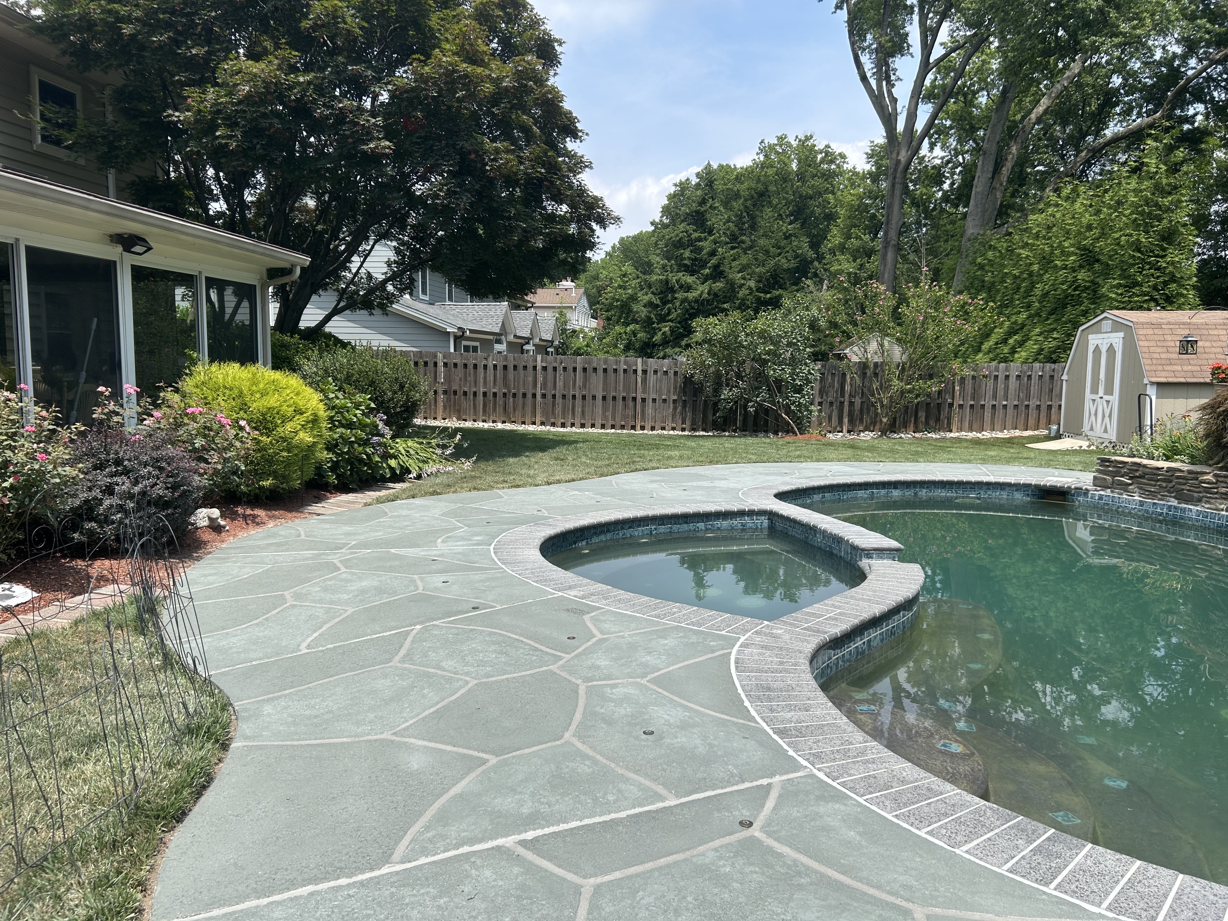 Residential pool deck in Granite Slate color theme after concrete resurfacing.
