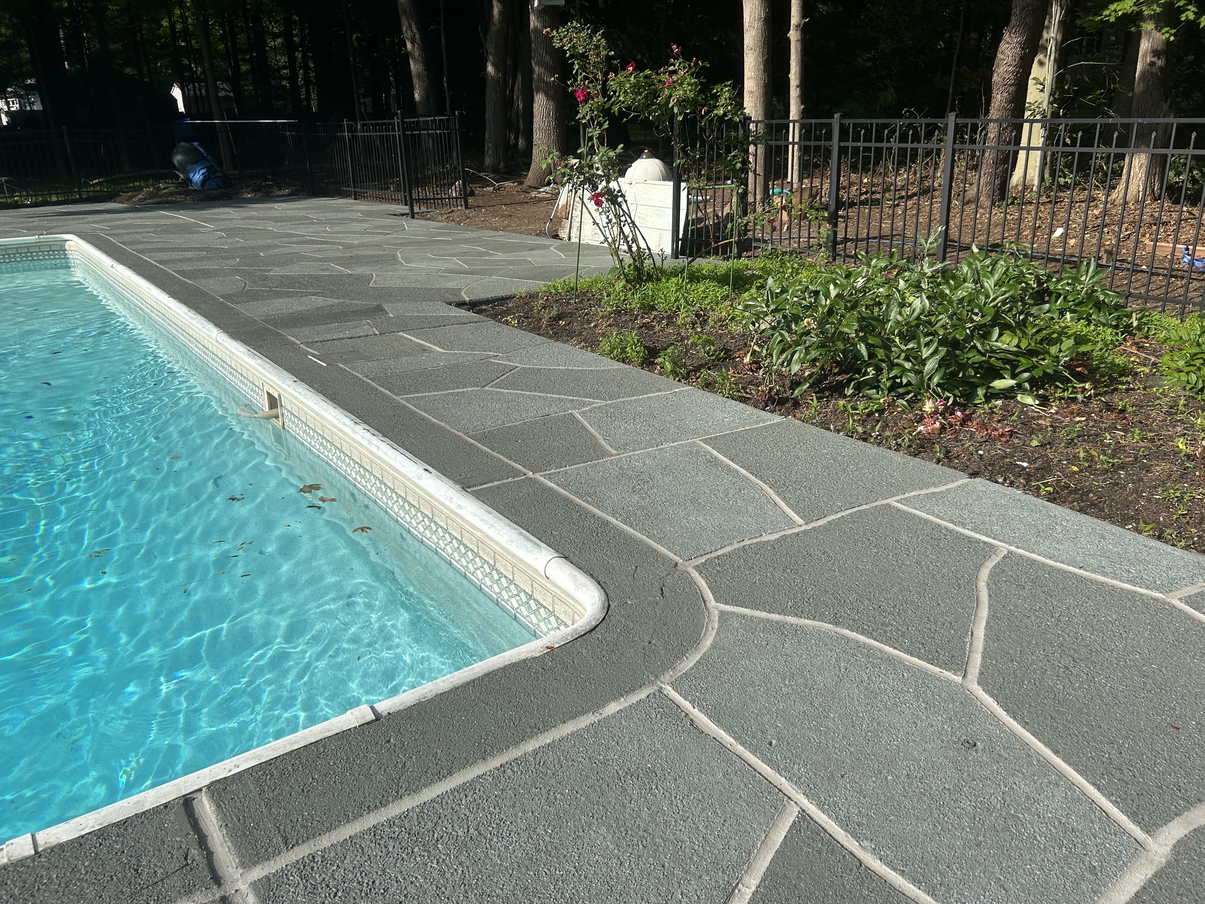 Resurfaced concrete pool deck in Granite Slate finish showing modern gray stone appearance.