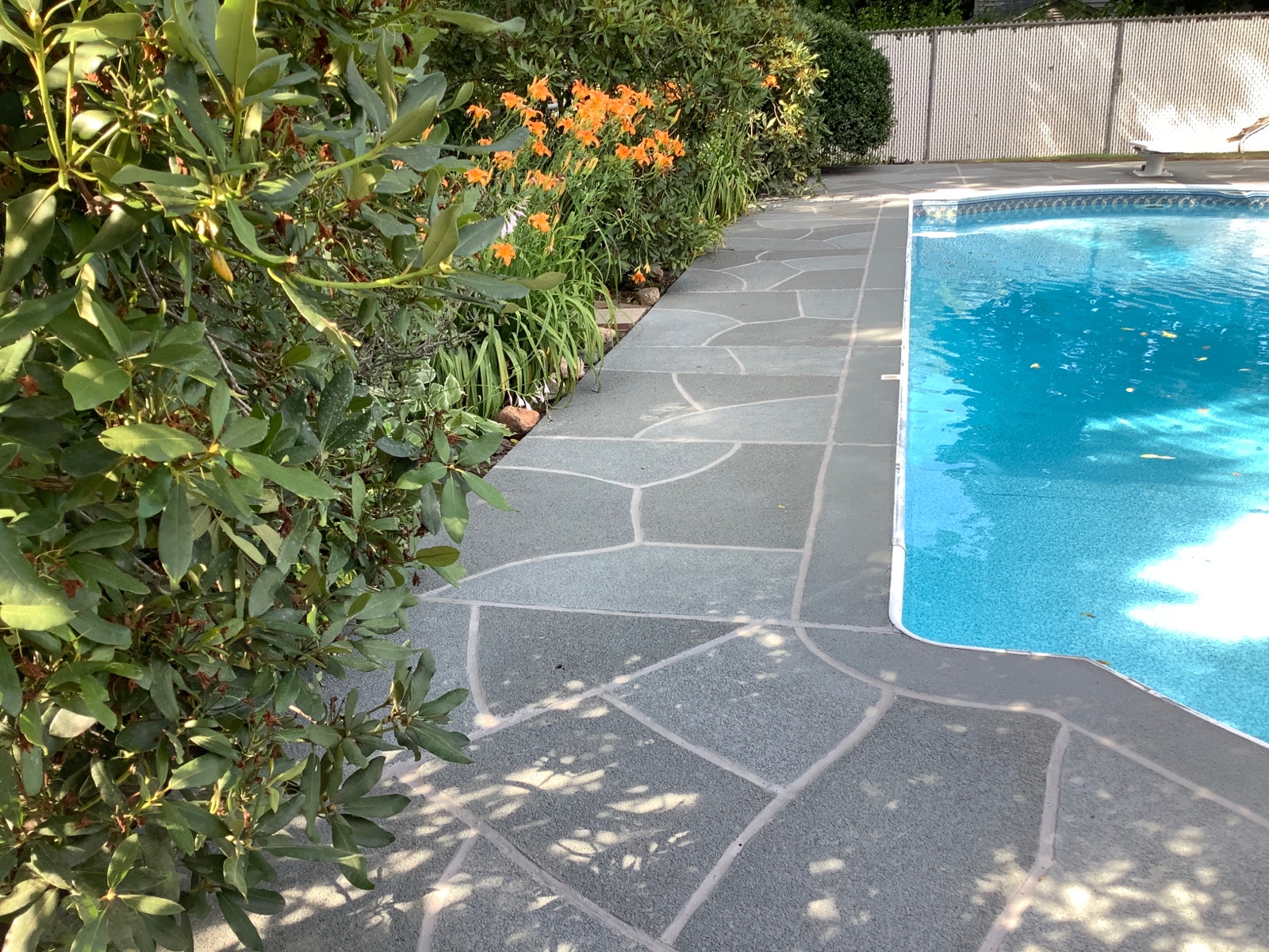 Residential pool deck in Granite Slate color theme after concrete resurfacing.
