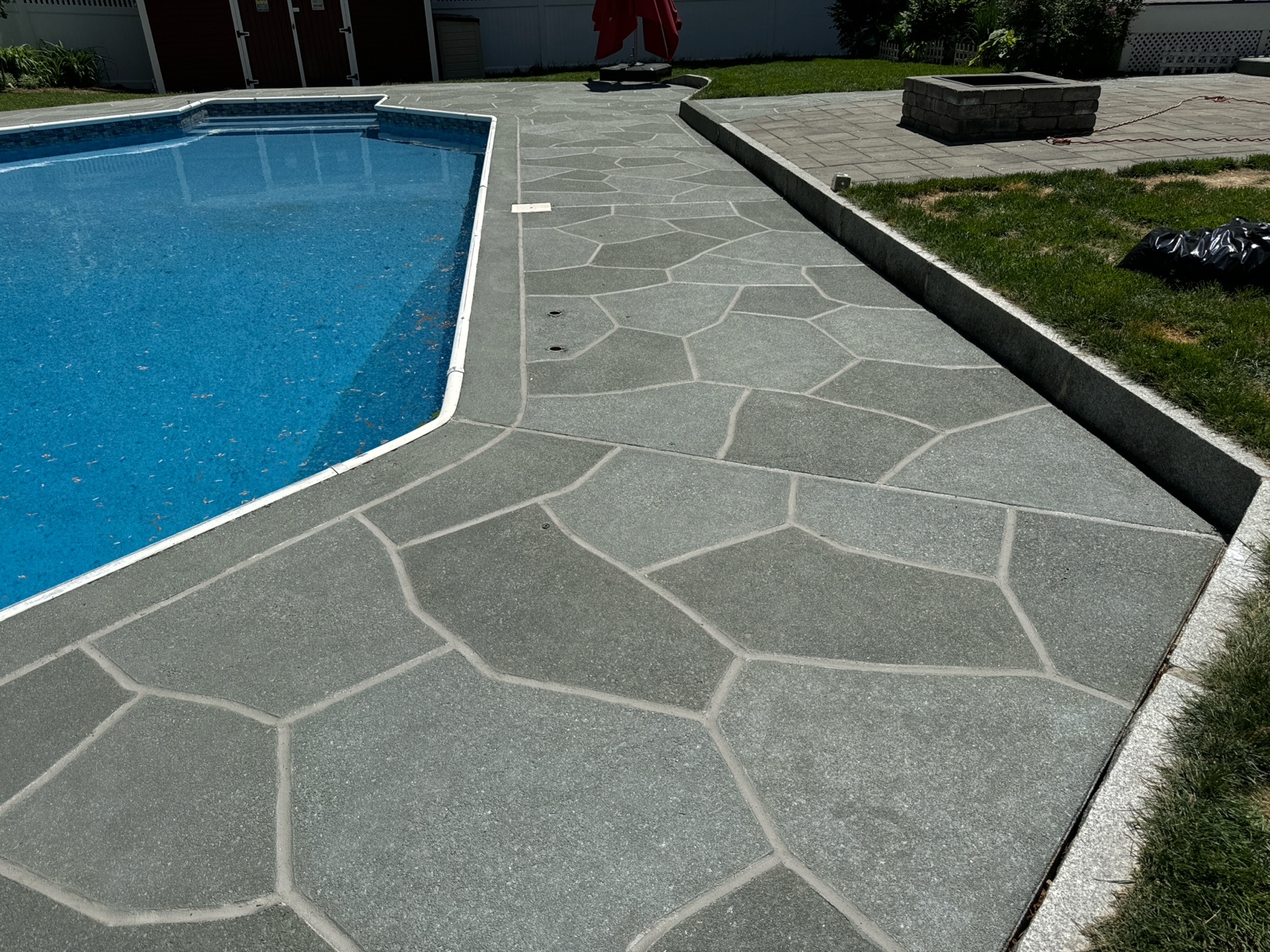 Upgraded concrete pool deck in Granite Slate finish in Doylestown, PA with clean gray slate look.