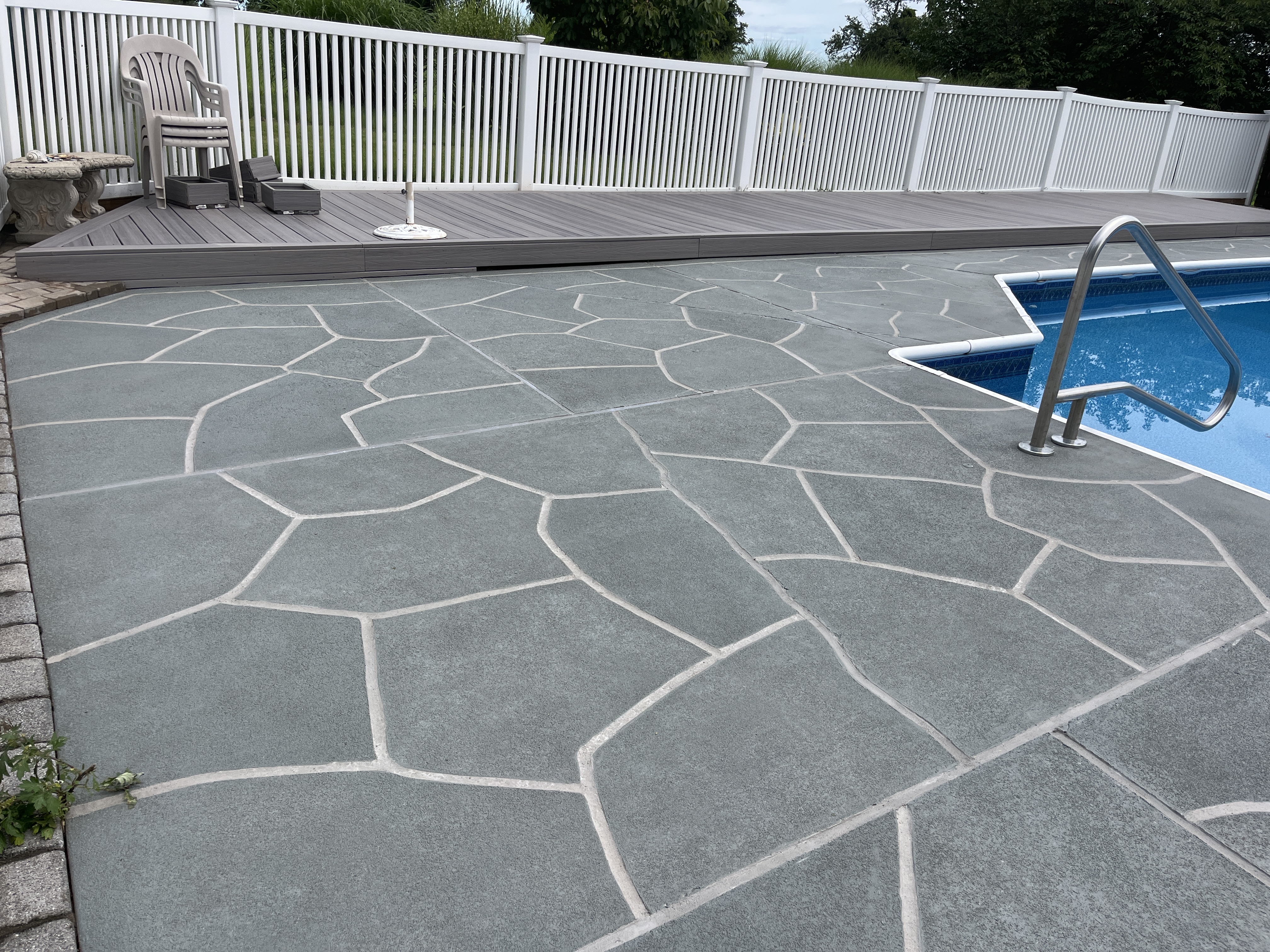 Resurfaced concrete pool deck in Granite Slate finish showing modern gray stone appearance.