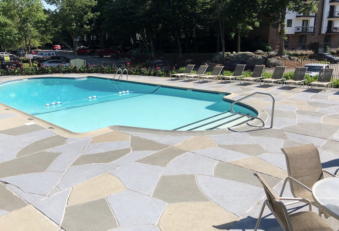 Upgraded concrete pool deck in Granite Slate finish in Providence, RI with clean gray slate look.