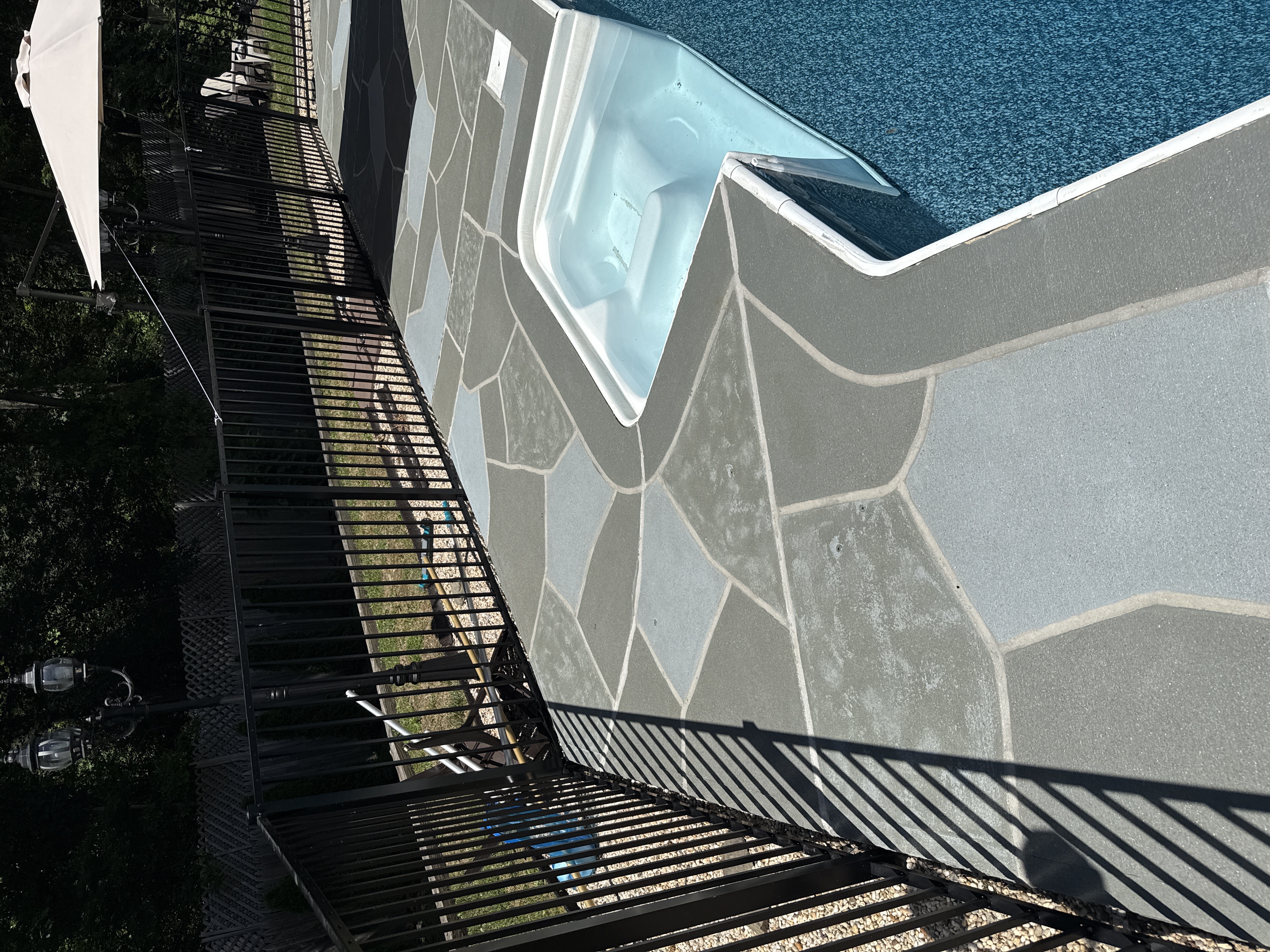 Upgraded concrete pool deck in Granite Slate finish with clean gray slate look.