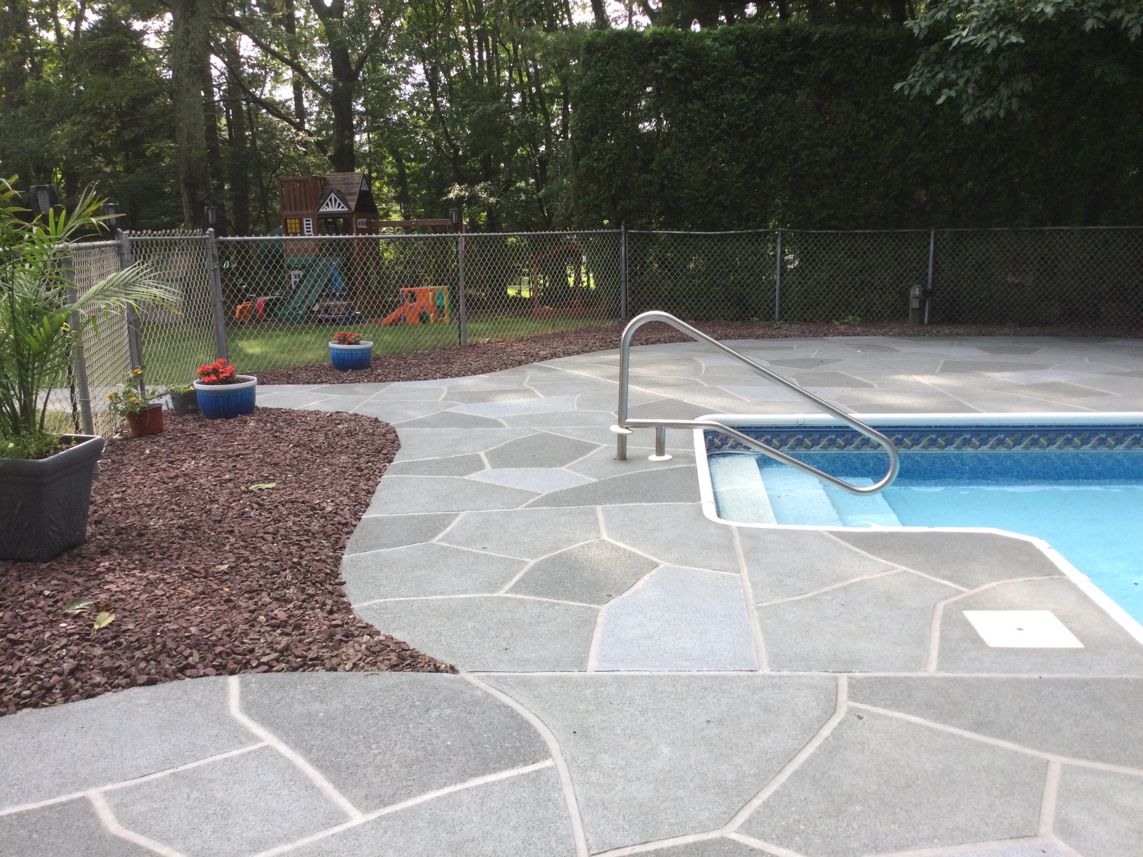 Resurfaced concrete pool deck in Granite Slate finish showing modern gray stone appearance.