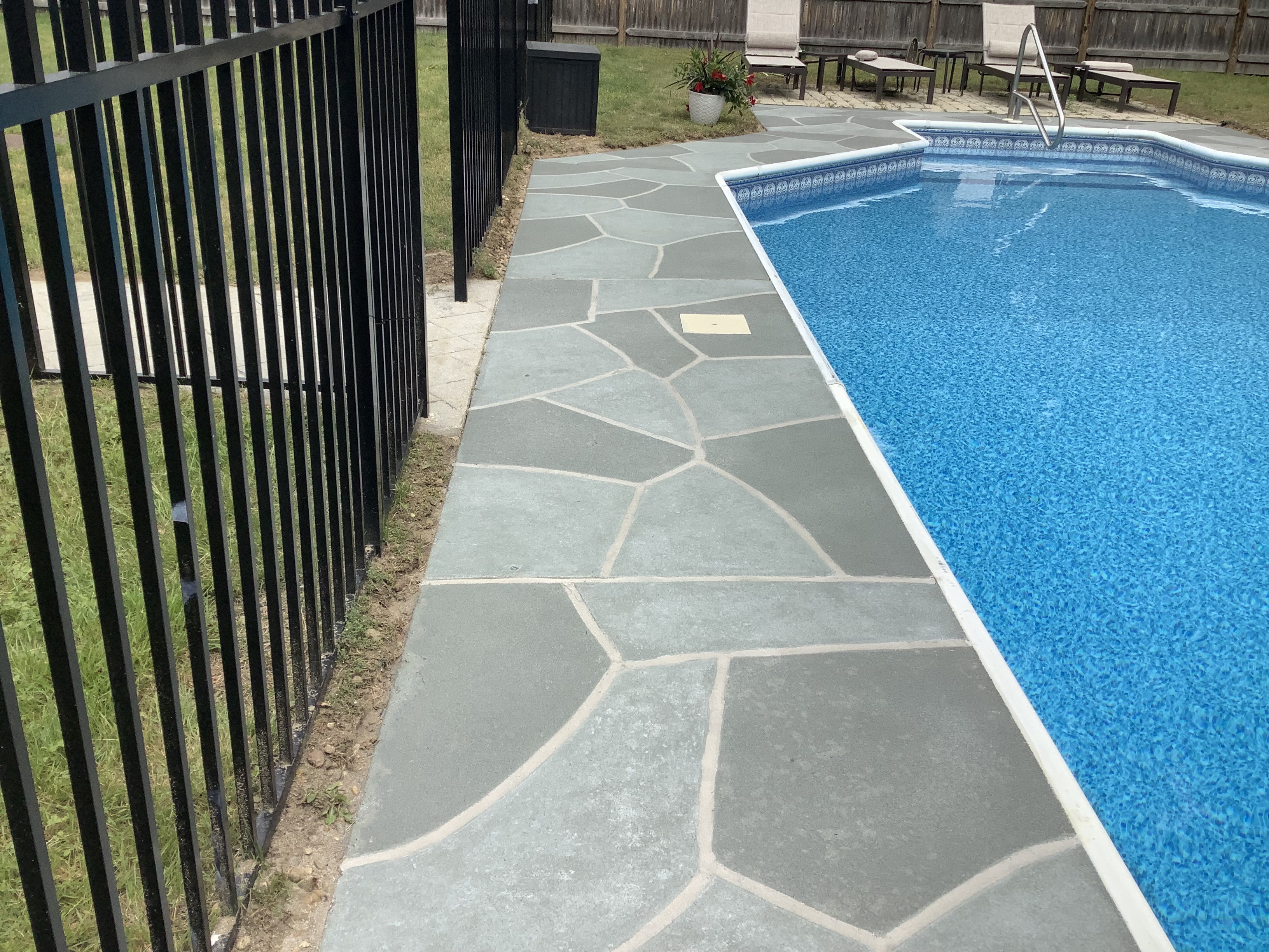 Resurfaced concrete pool deck in Granite Slate finish showing modern gray stone appearance.