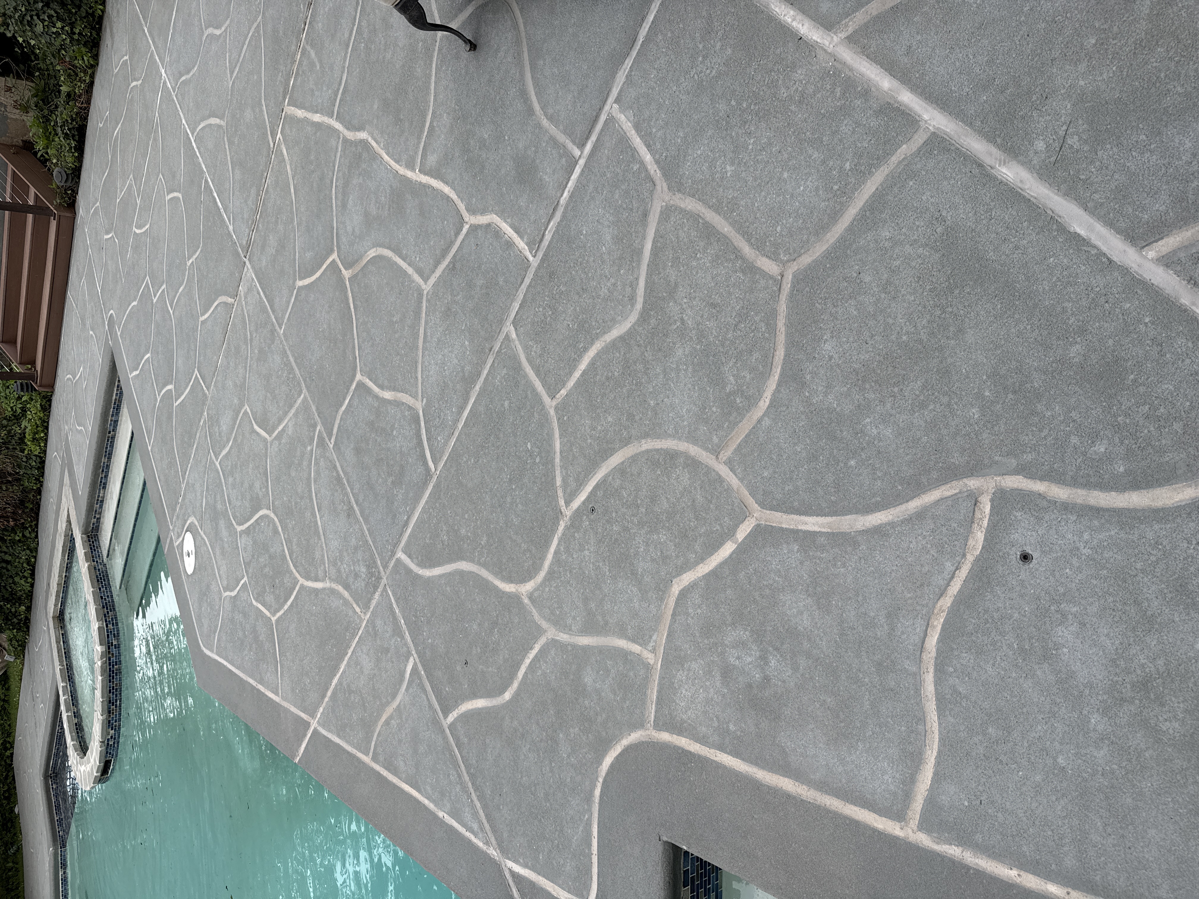 Upgraded concrete pool deck in Granite Slate finish with clean gray slate look.