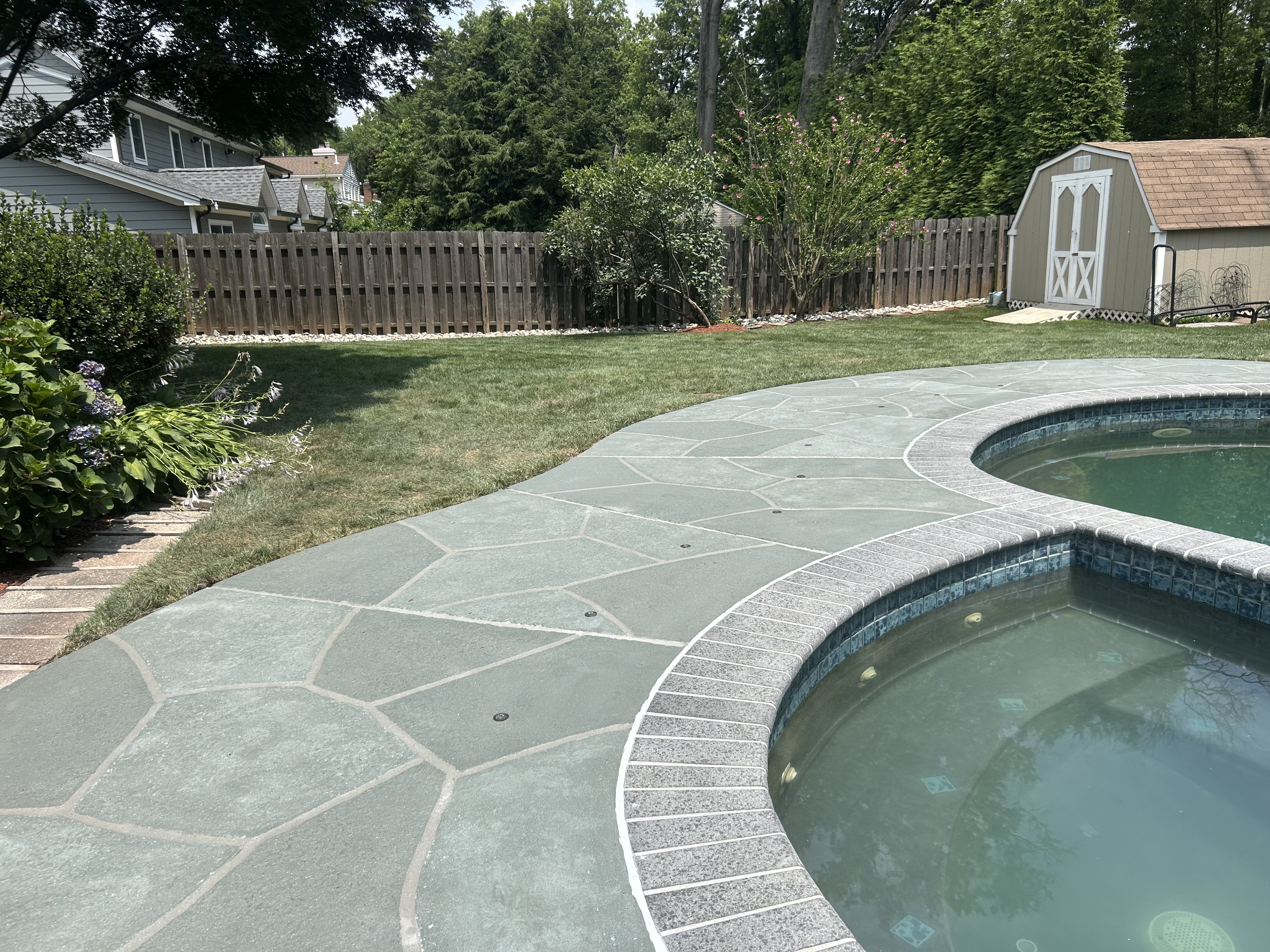 Resurfaced concrete pool deck in Granite Slate finish in Warwick, RI showing modern gray stone appearance.