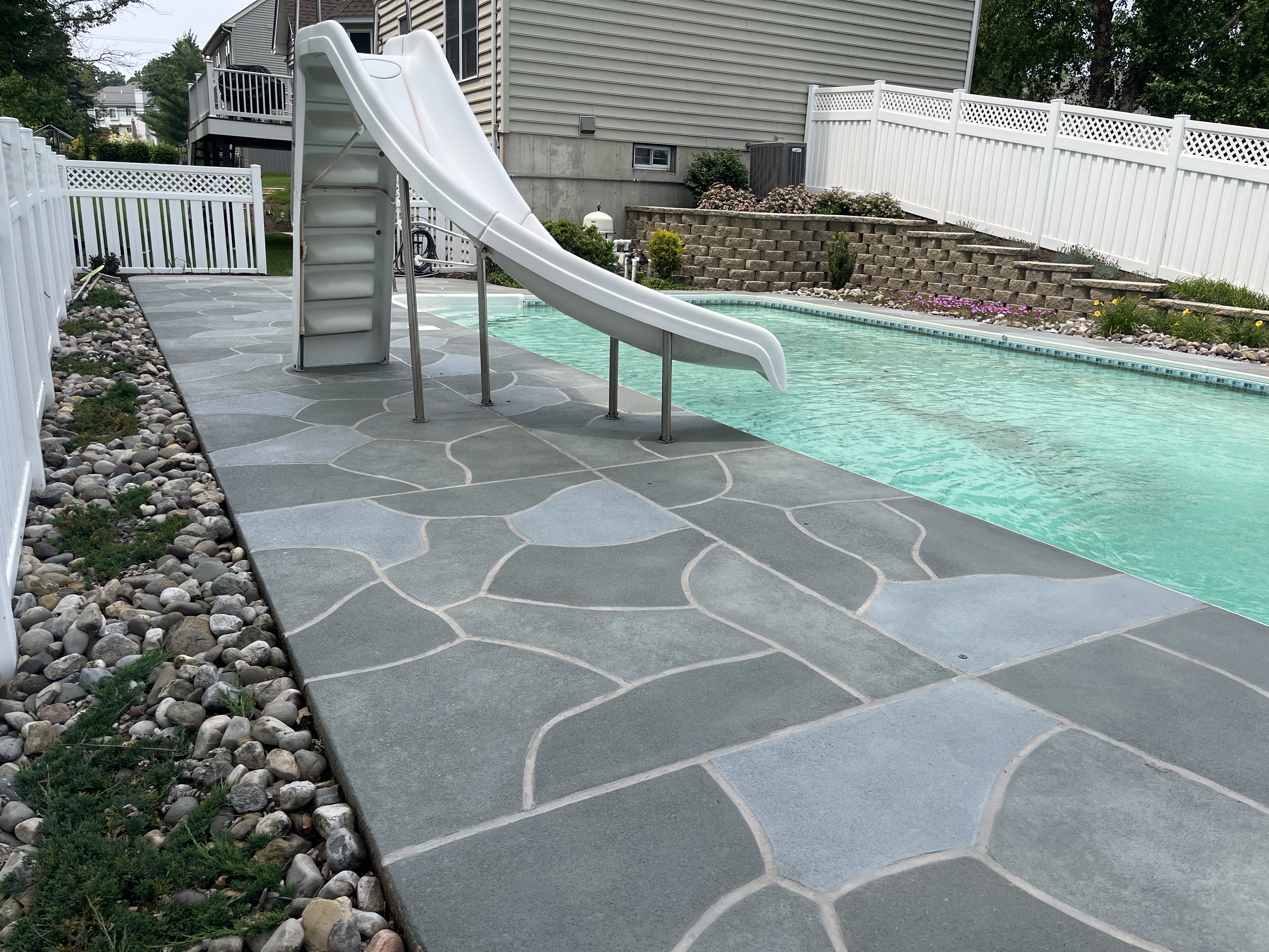 Residential pool deck in Granite Slate color theme after concrete resurfacing.