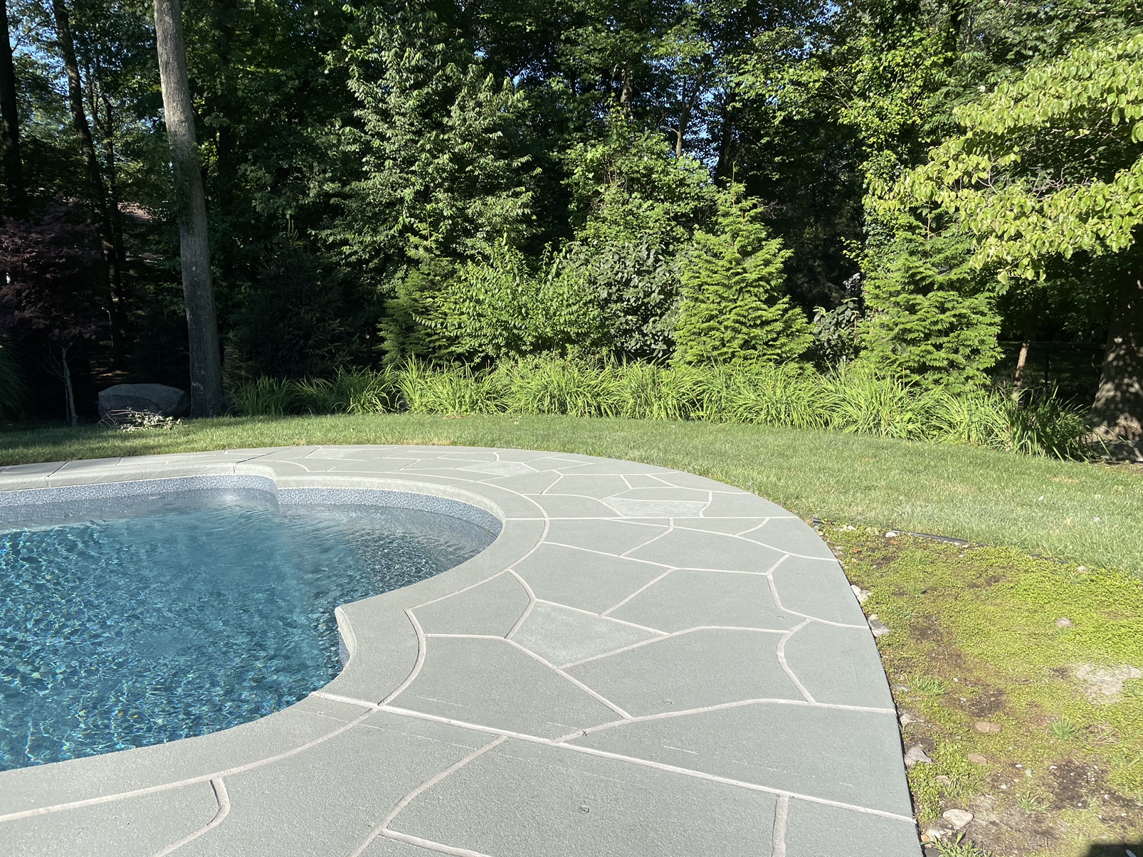 Residential pool deck in Granite Slate color theme after concrete resurfacing.