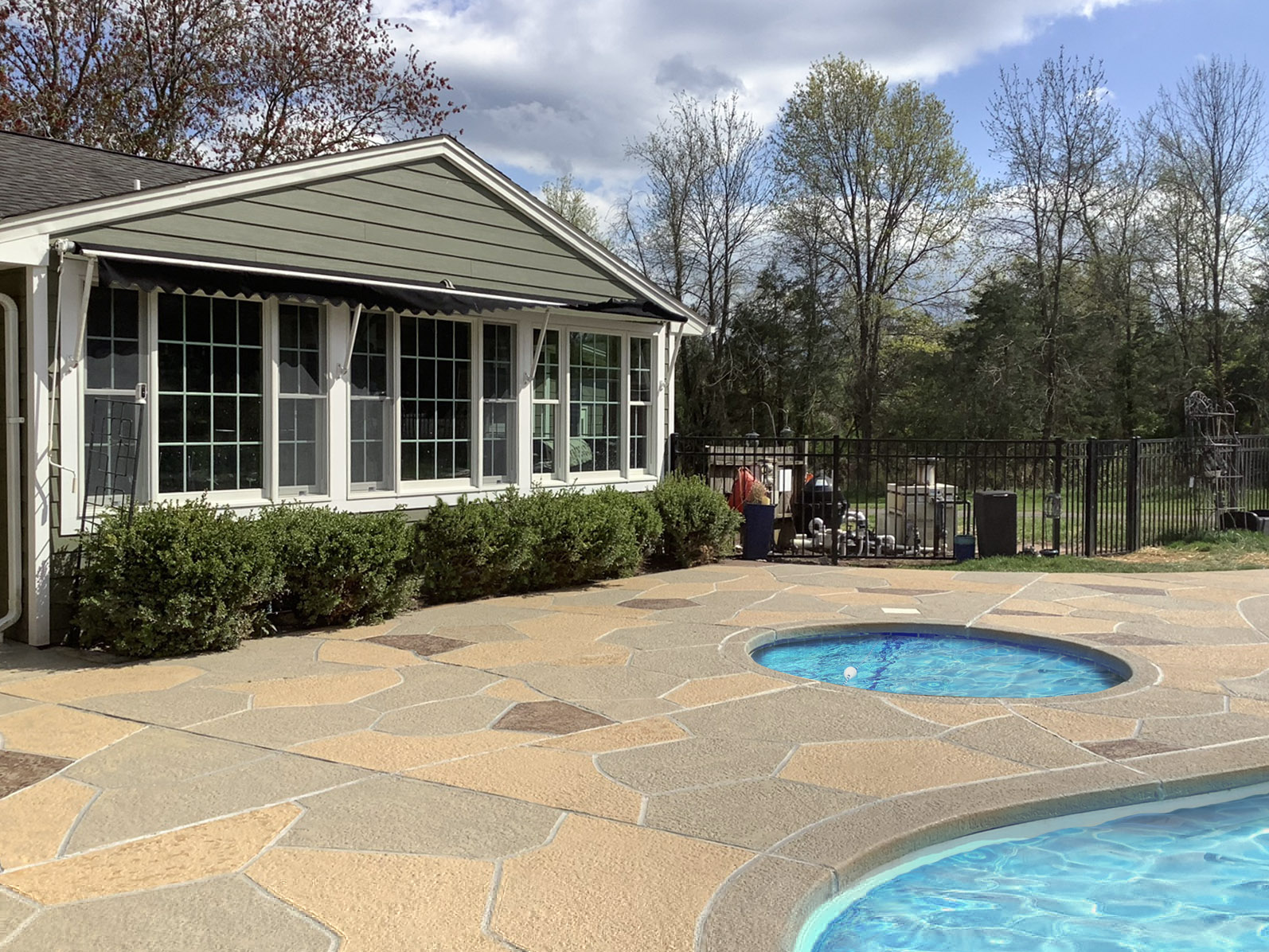 RenuKrete resurfaced pool deck in Hurricane Slate showing deep gray stone tones