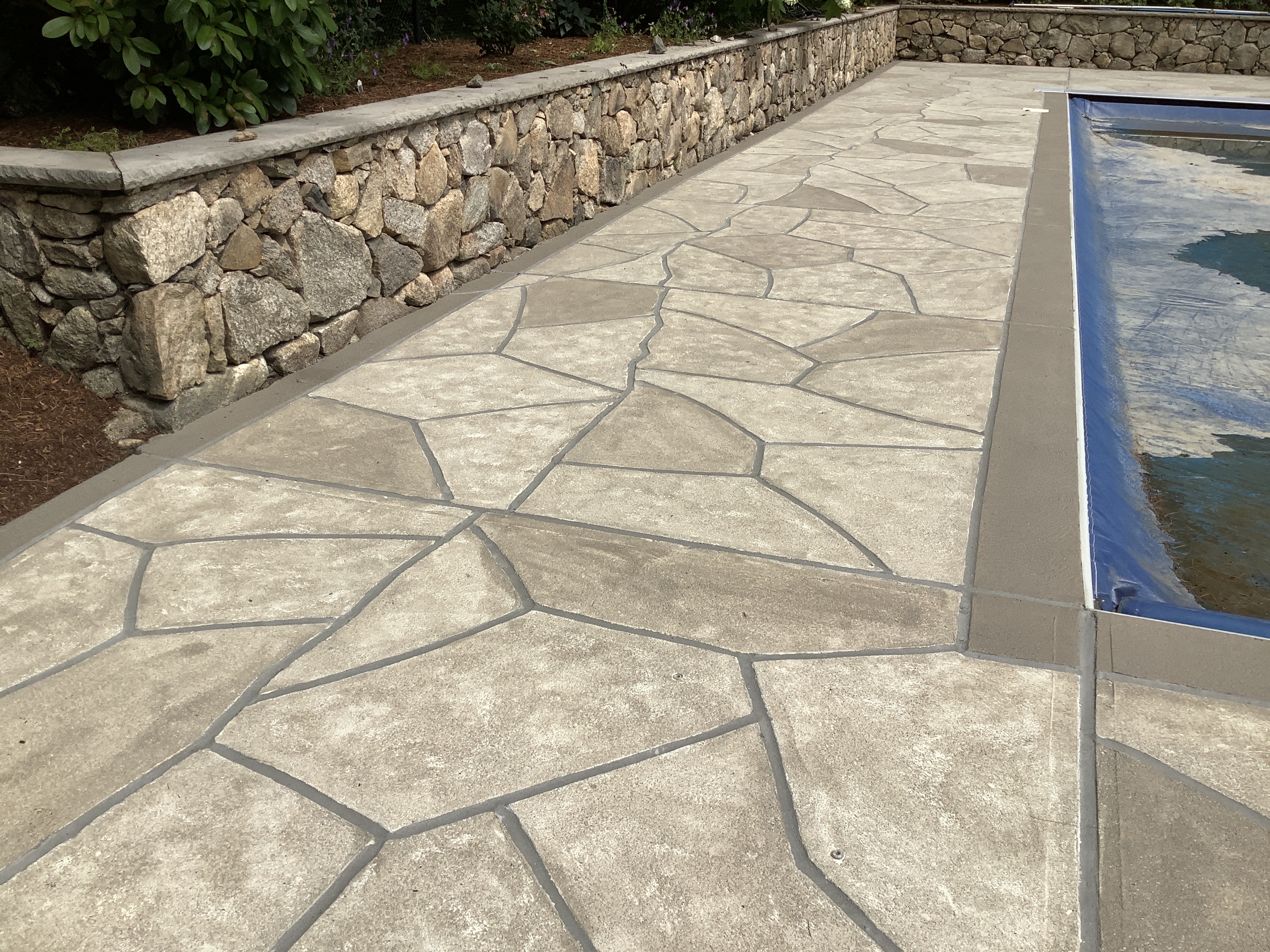 Warm-toned Sandstone pool deck renovation displaying light, warm stone aesthetic in Warwick, RI