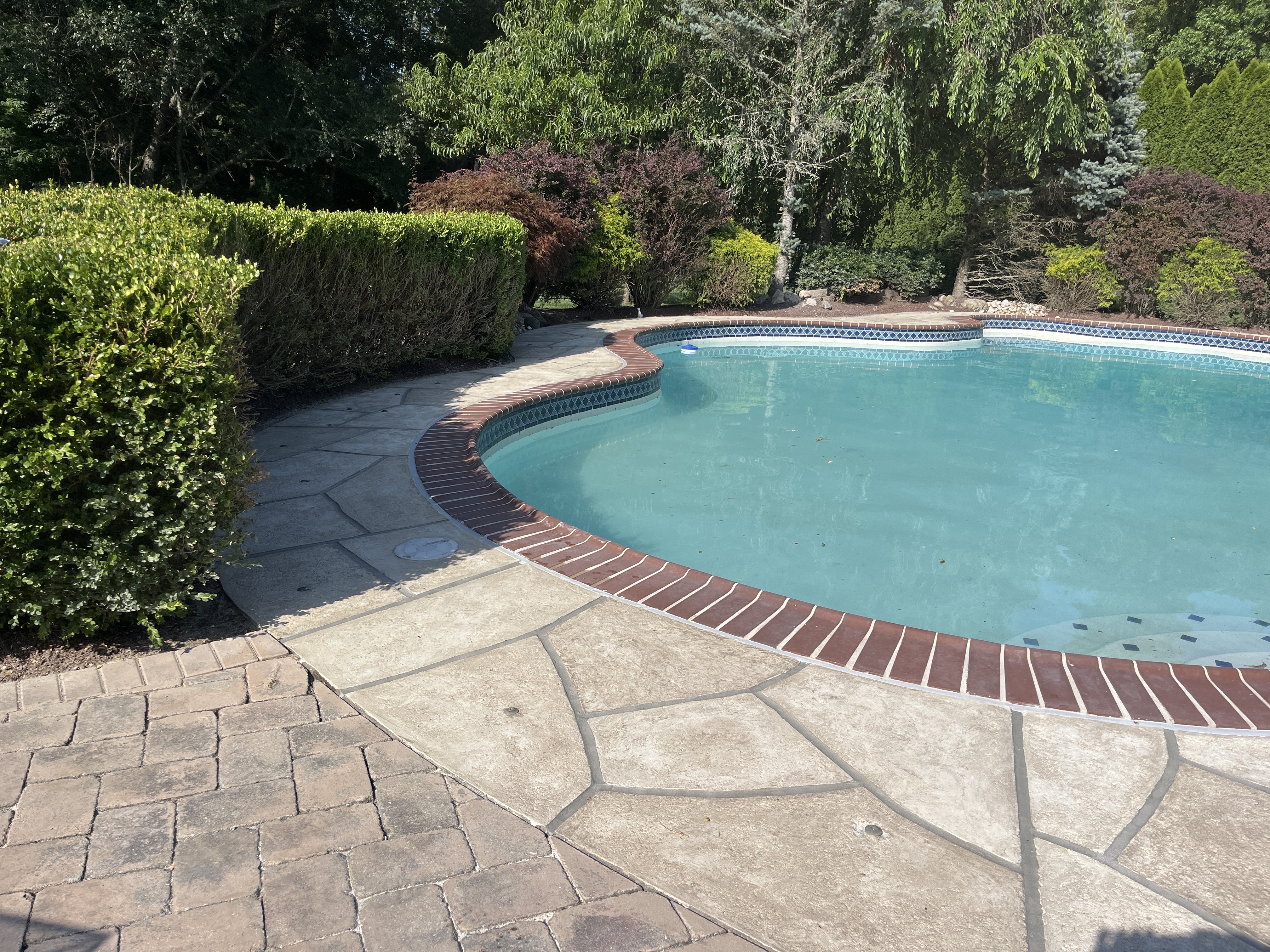 Sandstone concrete pool deck repair featuring durable resurfaced concrete in Warwick, RI