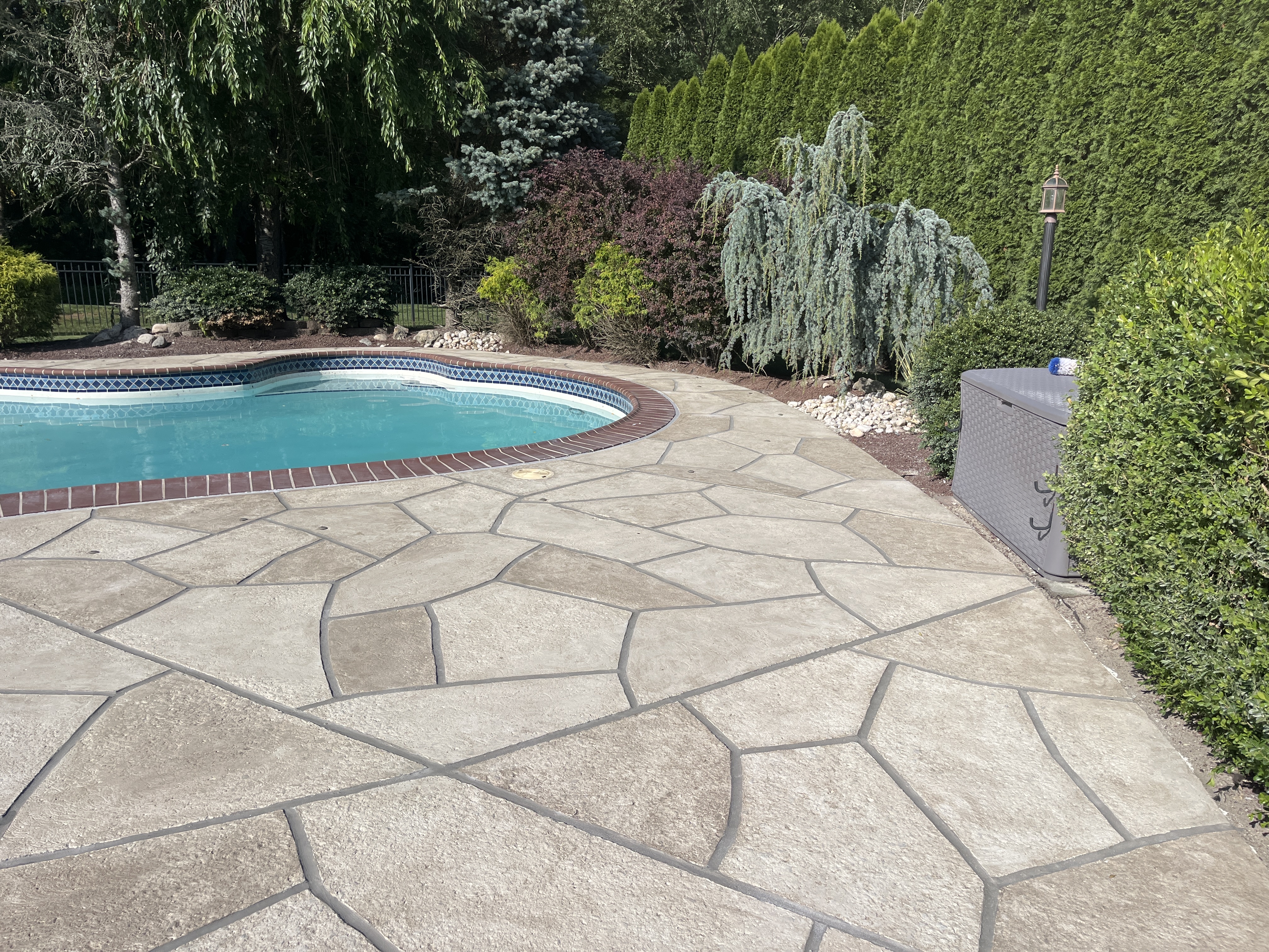 RenuKrete resurfaced pool deck in Sandstone showing light, warm stone aesthetic