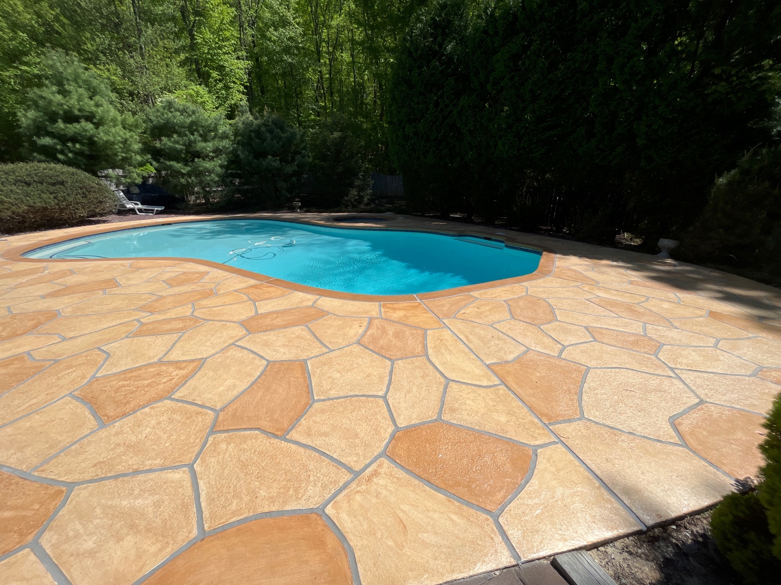 Warm-toned Tuscany pool deck renovation with subtle textured surface