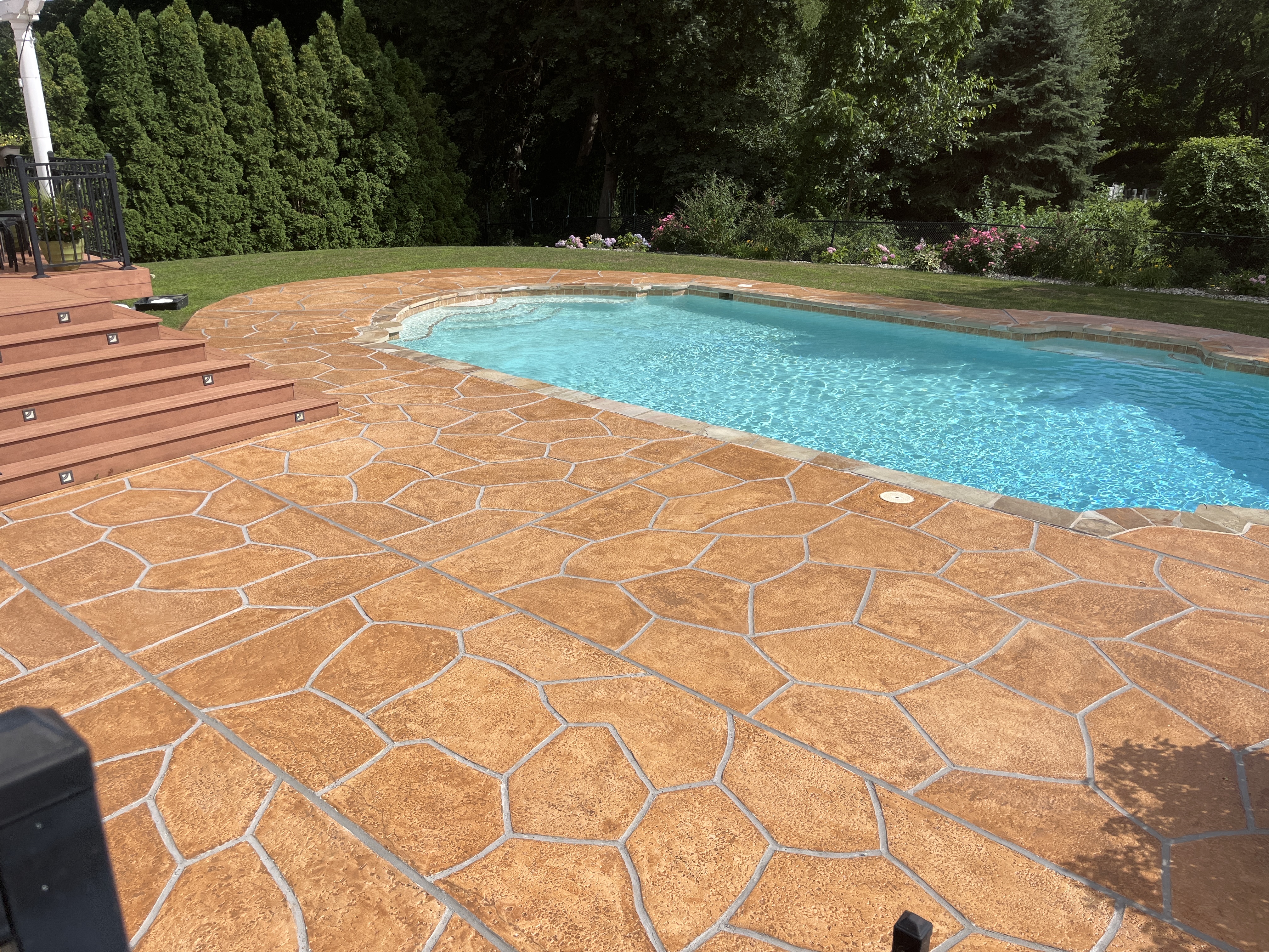Pool deck resurfaced in Tuscany finish showing durable resurfaced concrete in Plymouth, MA